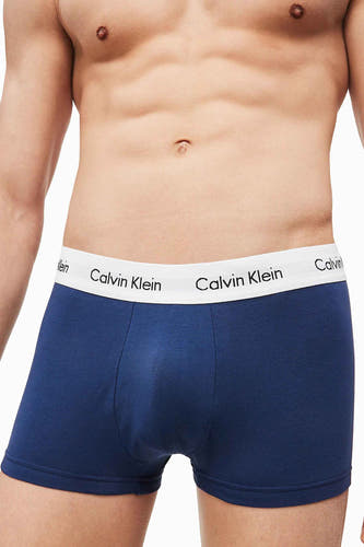 Boxer short en coton bleu de Calvin Klein avec une ceinture blanche à logo, porté par un modèle masculin.
