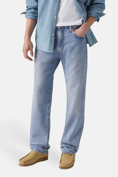 Jeans straight van lichtblauw denim van Levi's®, met een ontspannen pasvorm en bruine schoenen.
