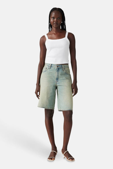 Korte lichtblauwe denim short van Levi's, gecombineerd met een wit topje en sandalen.