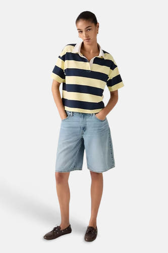 Lichtblauwe denim shorts van Levi's® met rechte pasvorm, gedragen met gestreept polo en bruine schoenen, front view.