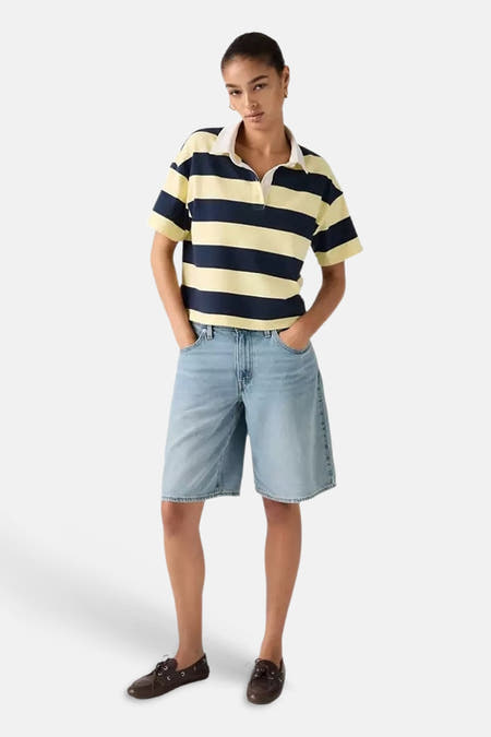 Lichtblauwe denim shorts van Levi's® met rechte pasvorm, gedragen met gestreept polo en bruine schoenen, front view.