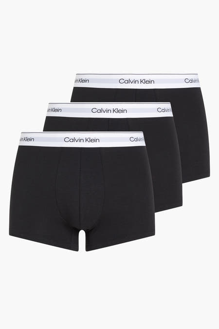 Zwarte boxershorts van Calvin Klein, met een witte elastische tailleband met logo in close-up.
