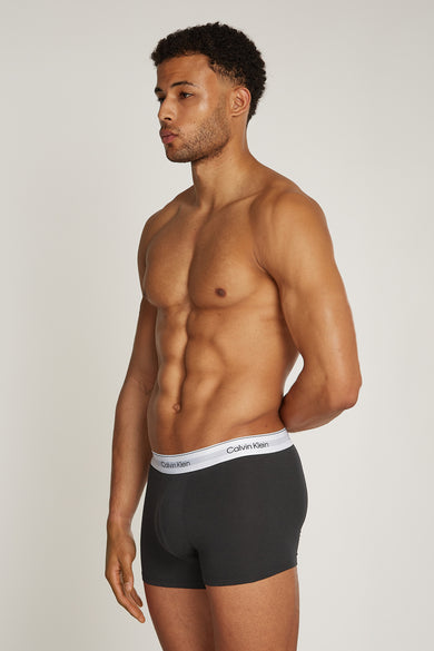 Man in grijze Calvin Klein-boxershort, staand.
