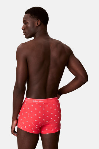 Rode boxershort van Calvin Klein met een wit "ck" logo all-over print, getoond op een model van achteren.
