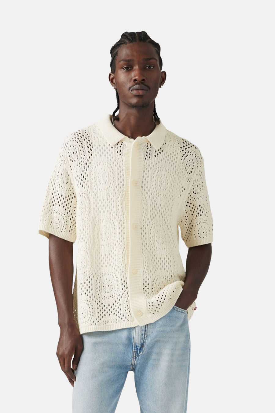 T-shirt blanc tricoté à manches courtes de Levi's, avec un motif ajouré ouvert, porté avec des jeans bleu clair.