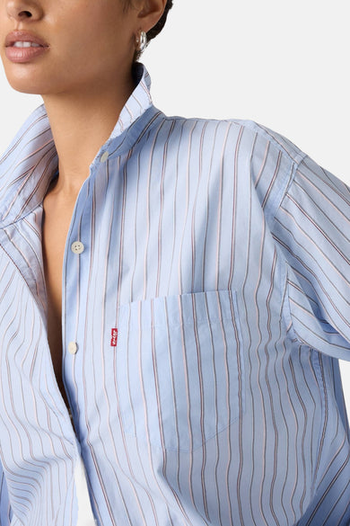 Chemise bleue à rayures à manches longues de Levi's®, avec une poche poitrine et des anneaux d'oreille argentés.