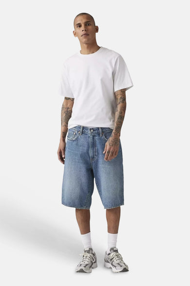 Lichtblauwe spijkershorts van Levi's® met relaxte pasvorm en gerafelde zoom, gestyled met een wit T-shirt.