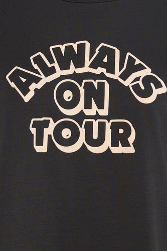 T-shirt à manches courtes noir Levi's® avec le texte "Always on tour" en beige.