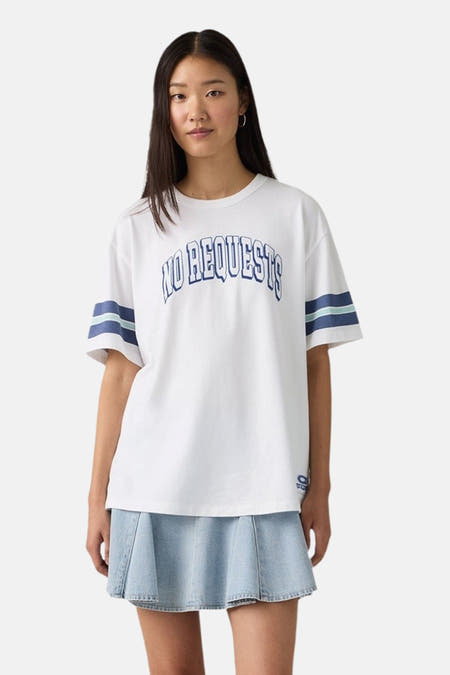 Wit T-shirt met korte mouwen van Levi's®, met blauwe tekst en strepen op de mouwen, gecombineerd met een denim rok.