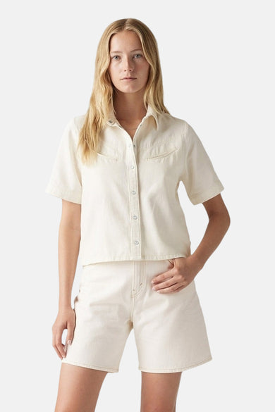 Ecru hemd met korte mouwen van Levi's, met knoopsluiting en borstzakken, gecombineerd met witte korte broek.
