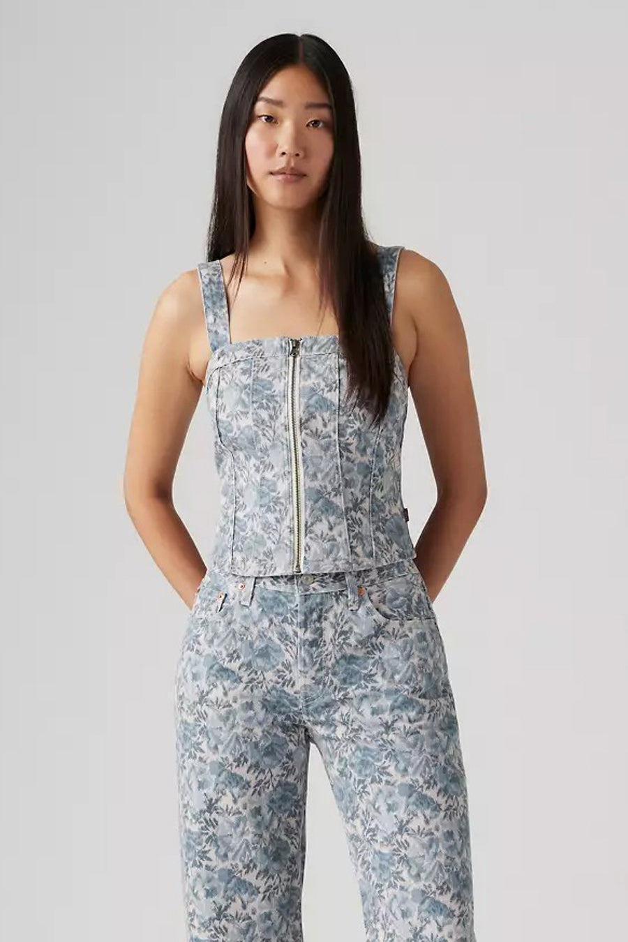 Blouse en denim bleu clair sans manches de Levi's® avec un motif floral et une fermeture à glissière à l'avant.
