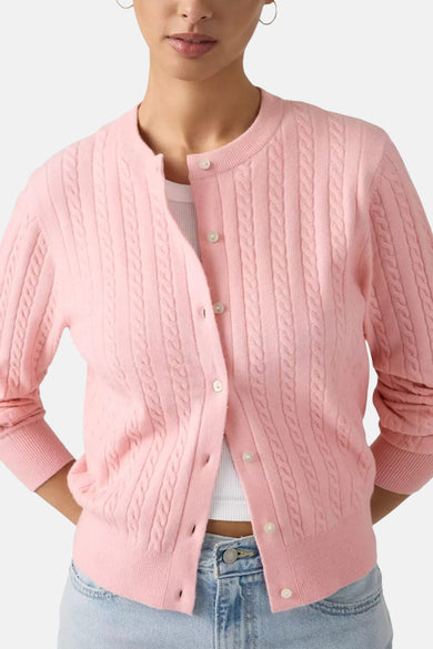 Roze gilet van Levi's, met kabelpatroon, lange mouwen en gedragen over een wit topje en een jeans.