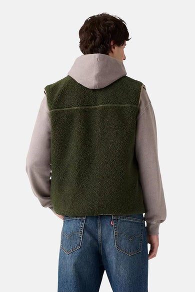Groene bodywarmer van Levi's, gedragen over een grijze hoodie en blauwe jeans, achterkant gezien.