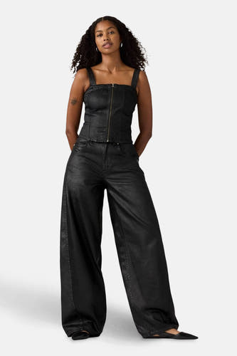 Jean denim noir spécial fit de Levi's, avec des jambes larges et porté par une femme avec un haut coordonné.