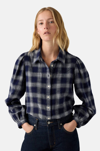 Blauw overhemd met lange mouwen van Levi's®, geruit en met pofmouwen, gecombineerd met een donkerblauwe jeans.
