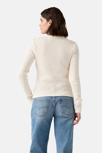 T-shirt blanc à manches longues de Levi's, avec une fine structure en côtes, associé à des jeans bleus.