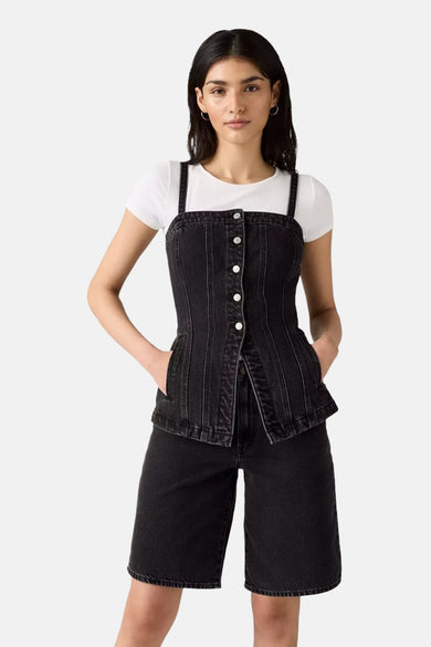 Zwarte denim tuniek van Levi's, gedragen over een wit T-shirt, met bijpassende korte broek en zilveren oorringen.