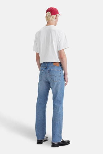 Lichtblauwe denim rechte jeans van Levi's®, met een bruin leren label op de achterkant, gecombineerd met een wit T-shirt en zwarte loafers.
