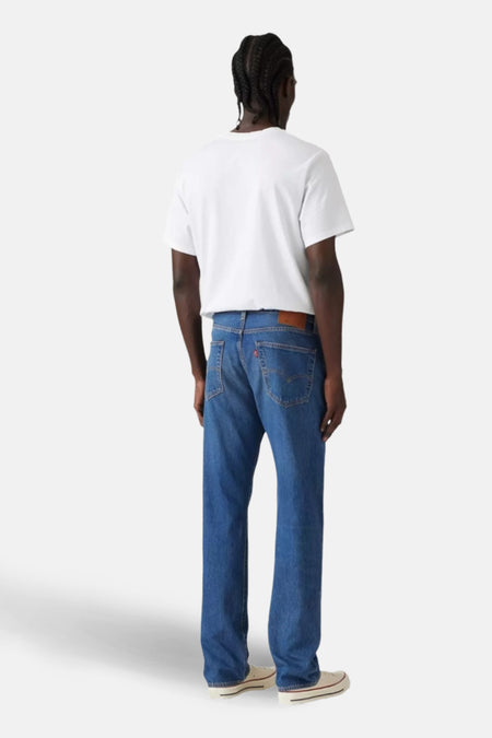 Man met witte T-shirt en blauwe jeans.