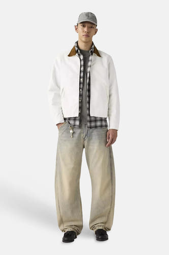 Jeans larges Levi's® en denim délavé bleu clair avec une coupe spéciale, portées avec une veste blanche et une chemise à carreaux.