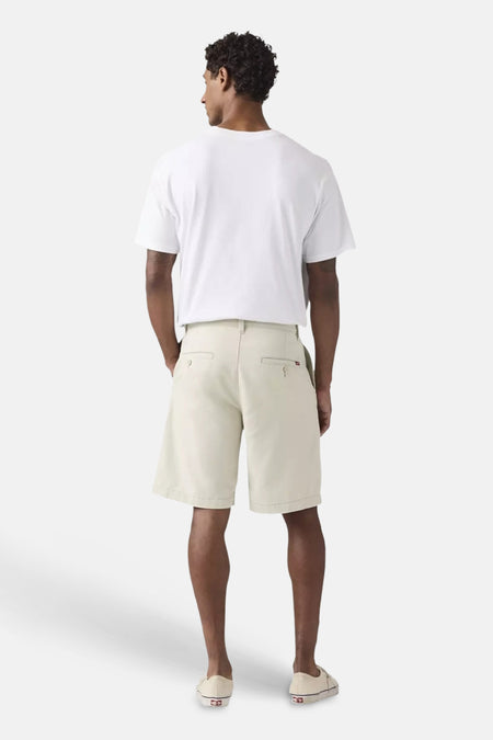 Ecru shorts van Levi's®, achterkant zichtbaar op een man met wit T-shirt en lichte instapschoenen.