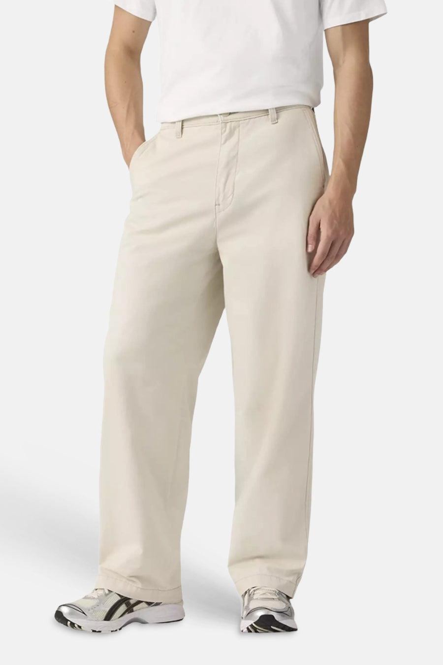 Beige chino van Levi's®, met een wijde pasvorm, gedragen met een wit T-shirt en sportschoenen.