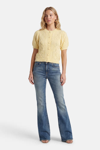 Gele gilet van Levi's, met korte mouwen, gebreid patroon en gedragen over een blauwe jeans.
