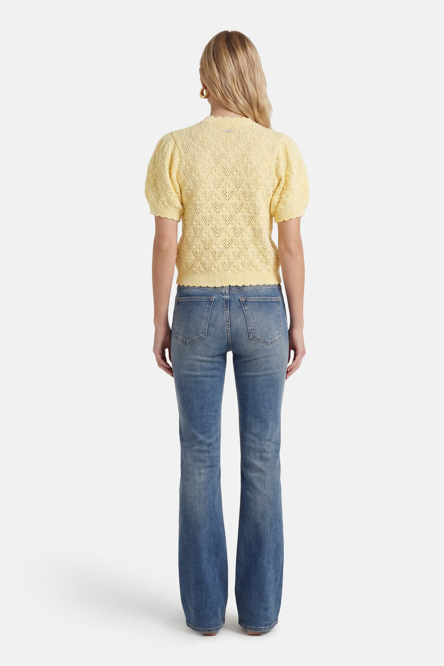 Gele gilet van Levi's, met korte pofmouwen en een gehaakt patroon, gecombineerd met een blauwe spijkerbroek.