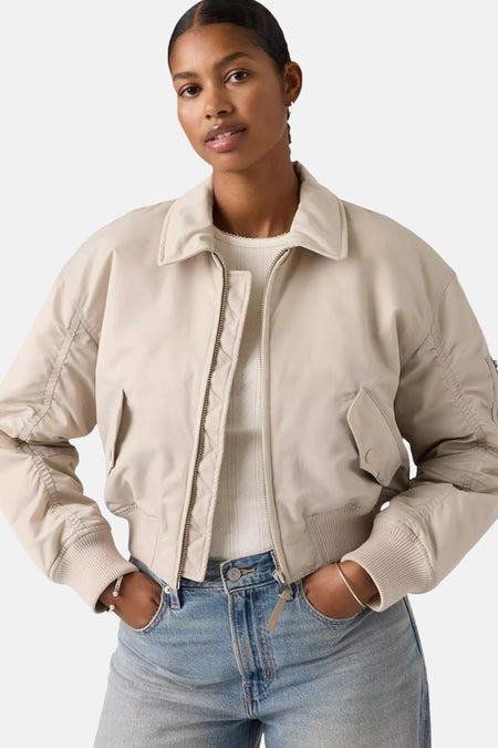 Grijze korte jas van Levi's®, met kraag en geribbelde manchetten, gedragen over een gebreide top en een jeans.
