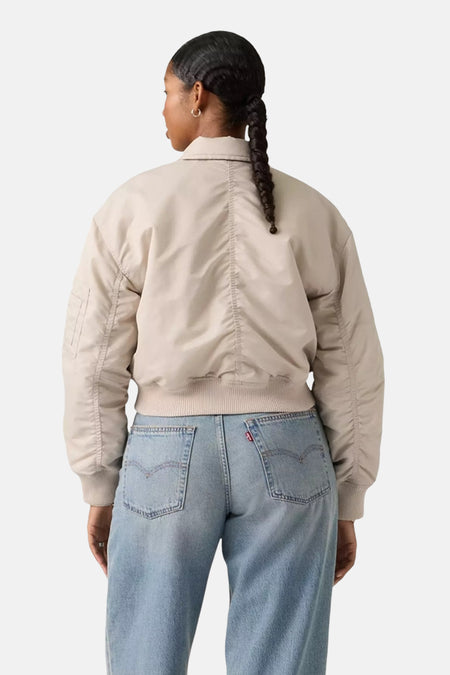 Grijze korte jas van Levi's, met lange mouwen en gedragen over een blauwe jeans.
