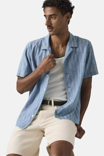 Lichtblauw overhemd met korte mouwen van Levi's®, met fijne ribstructuur, open kraag en gedragen over een wit hemd.