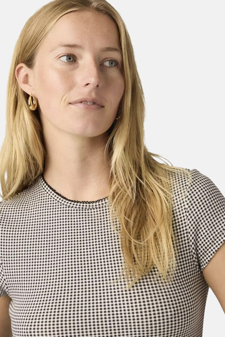 Zwart korte mouwen T-shirt van Levi's® met klein ruitpatroon en geborduurde kraag, gedragen door model met gouden oorbellen, close-up voorzijde