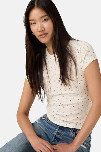 Wit T-shirt met korte mouwen van Levi's®, met kleine bloemetjesprint en verticale ribstructuur, gedragen met een blauwe jeans.
