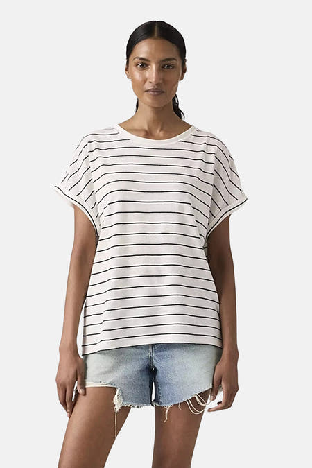 Wit gestreept T-shirt van Levi's, met korte mouwen en een losse pasvorm, gecombineerd met een denim short.
