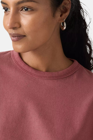 Roze T-shirt met korte mouwen van Levi's, close-up shot met een vrouw met zilveren oorringen.
