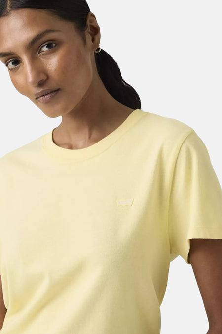 Geel T-shirt van Levi's®, gedragen door een model met een staart en gouden oorbel.