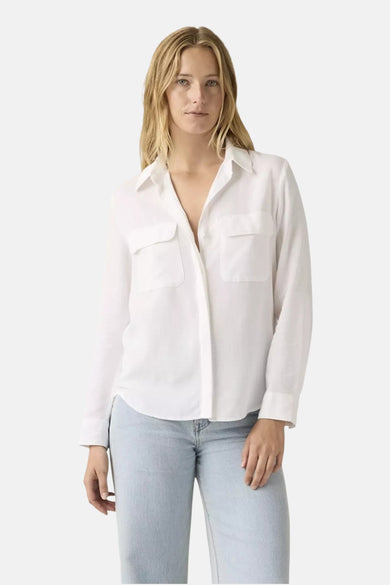 Chemise blanche à manches longues Levi's® avec poches poitrine, portée avec un jean clair.