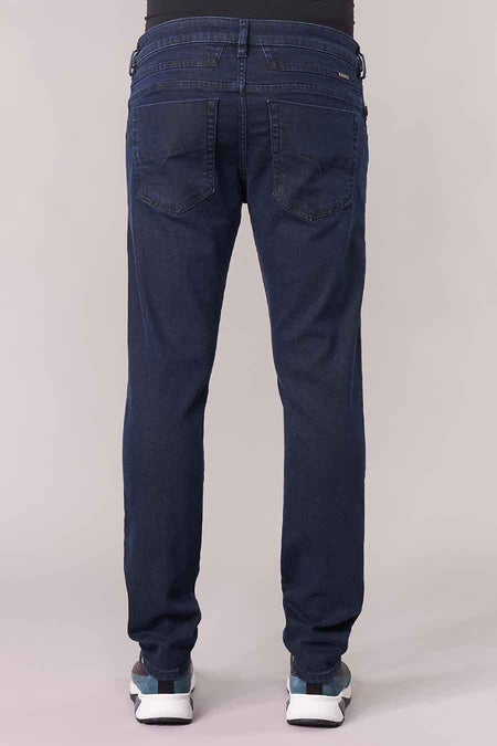 Donkerblauwe tapered jeans van Diesel, achterzijde met zakken en subtiele slijtage, model in staande houding