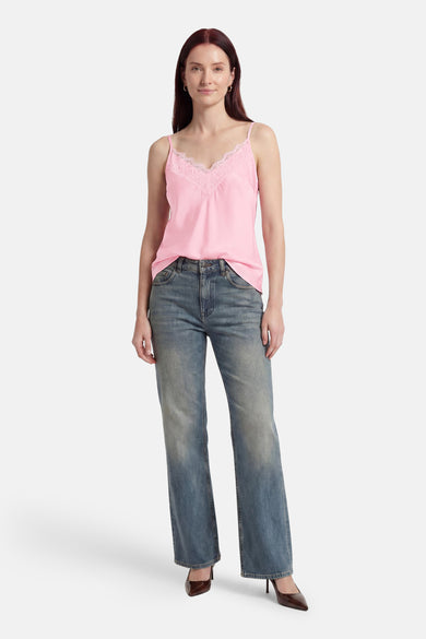 Roze tanktop van Terra di Siena met kanten V-hals, gedragen met blauwe jeans en bruine hakken.