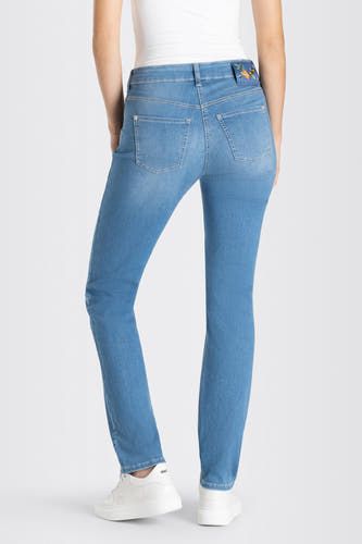 Lichtblauwe straight jeans van MAC, met witte sneakers.
