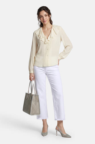 Off white wide jeans van MAC, gecombineerd met een crèmekleurige blouse met ruches, zilveren pumps en een geweven tas.