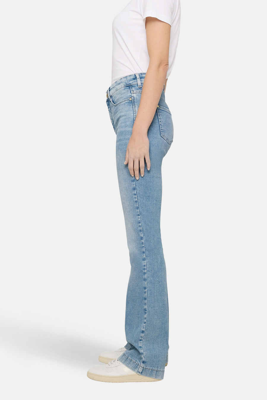 Lichtblauwe denim bootcut jeans van MAC, gedragen met een wit T-shirt en witte sneakers, zijaanzicht.
