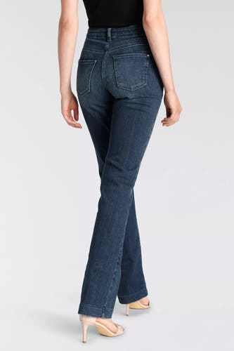 Jean bootcut bleu de MAC, avec taille haute et porté avec des talons hauts.