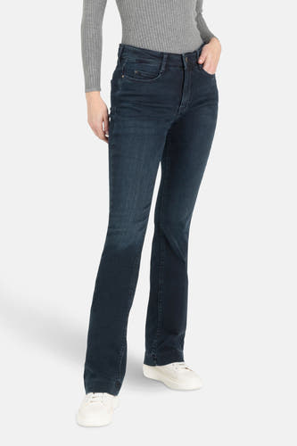 Jean bootcut en denim bleu marine de MAC, avec un pull gris rayé et des baskets blanches.