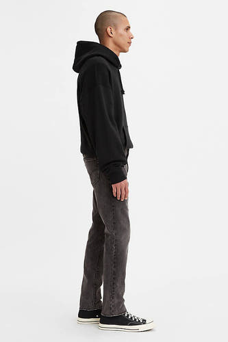 Donkergrijze slim fit jeans van Levi's® in denim, zijprofiel, met zwarte hoodie en sneakers