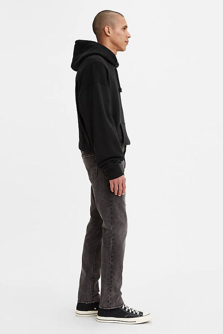 Donkergrijze slim fit jeans van Levi's® in denim, zijprofiel, met zwarte hoodie en sneakers