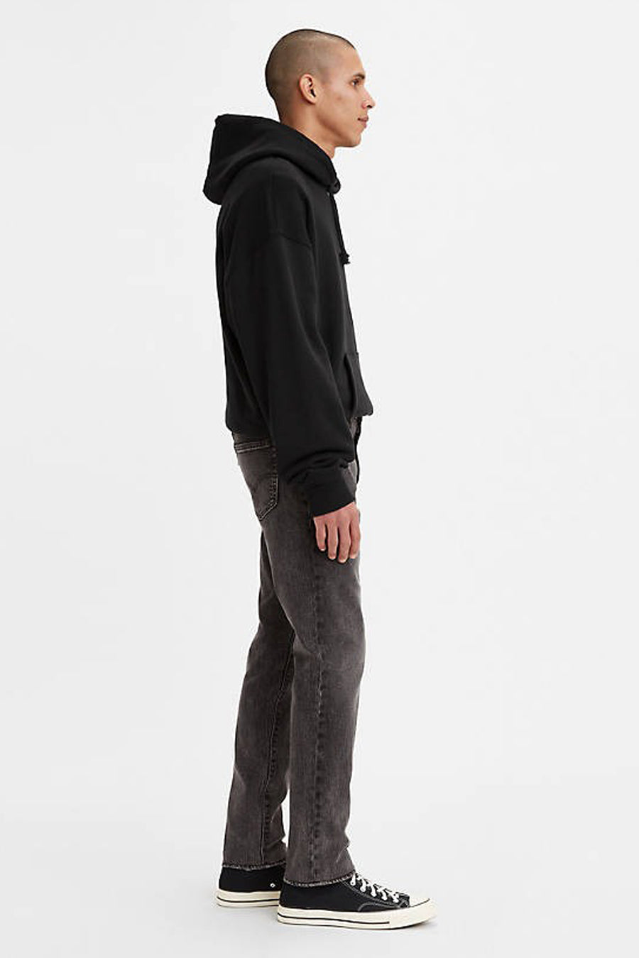 Donkergrijze slim fit jeans van Levi's® in denim, zijprofiel, met zwarte hoodie en sneakers