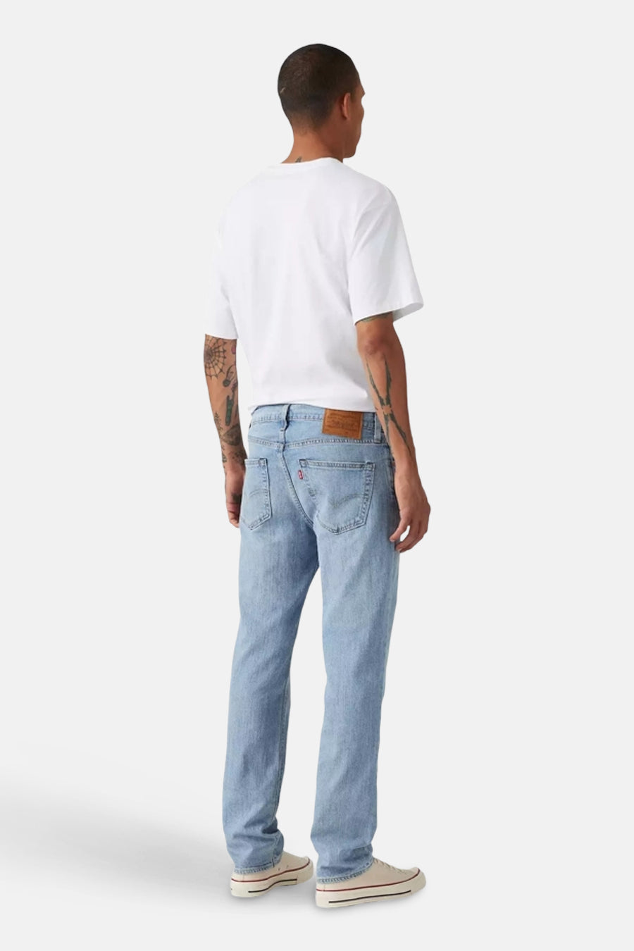 Lichtblauwe denim slim jeans van Levi's, gezien van achteren, met een witte t-shirt en witte schoenen.
