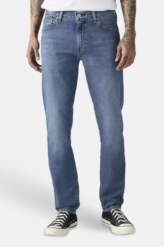 Slim-fit 511 jeans van Levi's® in mid-blauw denim, gedragen met een wit T-shirt en zwarte sneakers.