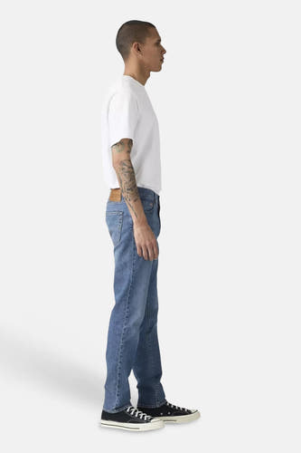 Slim fit jeans van middenblauw denim van Levi's®, gedragen door een man, in zijprofiel.